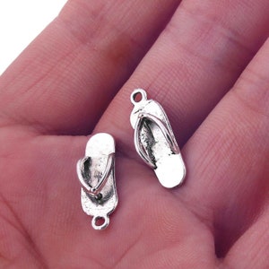 May include: Two silver-toned flip flop charms with a loop at the top for attaching to jewelry or other crafts.