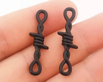 May include: A pair of black barbed wire earrings. The earrings are made of metal and have a twisted barbed wire design.