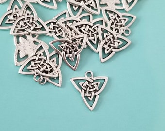 May include: A pile of silver-toned metal charms in the shape of a Celtic knot. The charms are triangular and have a hole at the top for hanging.