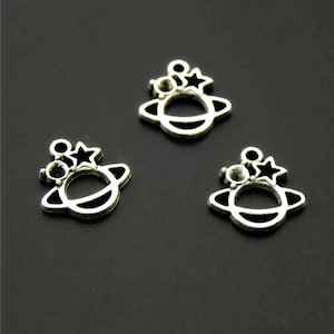 May include: Three silver charm pendants in the shape of a planet with a star and a small circle on top. The charms are perfect for jewelry making or adding to a keychain.