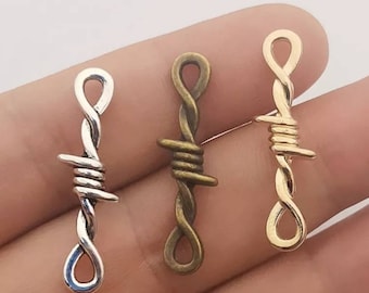 May include: Three silver, gold, and bronze barbed wire charms. The charms are shaped like a piece of barbed wire and are perfect for adding a touch of edgy style to jewelry.