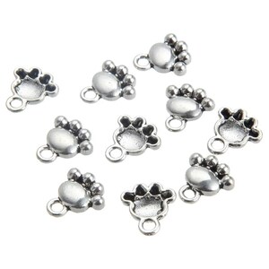 May include: Ten silver paw print charms with a loop for attaching to jewelry or other crafts.