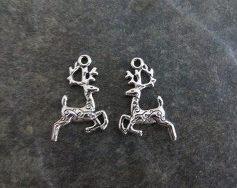 May include: Two silver reindeer charms with intricate details. The reindeer are in a running pose with their antlers raised.