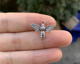 May include: Silver bee charm with detailed wings and a textured body.