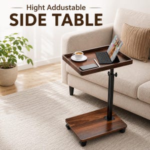 May include: A height adjustable side table with a dark wood grain finish, a black metal support post, and four caster wheels. The tabletop holds a tablet, a keyboard, a stylus, and a white coffee cup on a saucer. Text reads: Hight Addustable SIDE TABLE.