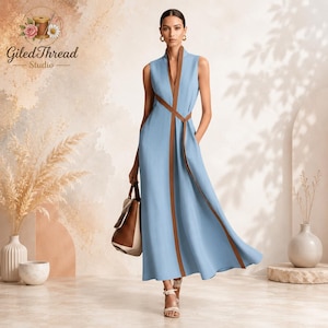 May include: A sleeveless light blue maxi dress featuring a deep V-neckline and a brown vertical trim that wraps around the waist as a tie. The dress has a flowing skirt and is paired with a brown and white handbag and light-colored strappy sandals.