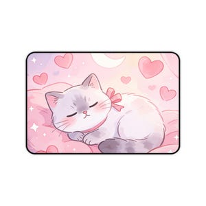 Peut inclure: Un tapis de bureau rectangulaire présentant une illustration à l'aquarelle d'un chat blanc endormi avec des marques grises, portant un collier et un nœud roses. Le fond est un dégradé rose doux rempli de cœurs rouges, d'étoiles et d'un croissant de lune.