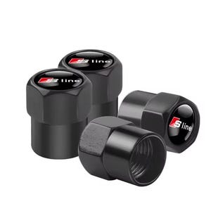 Puede incluir: Un juego de cuatro tapones de válvula de neumático cilíndricos de color negro con una sección superior hexagonal. Cada tapón presenta una incrustación circular negra en la parte superior con el logotipo S line en rojo y blanco.