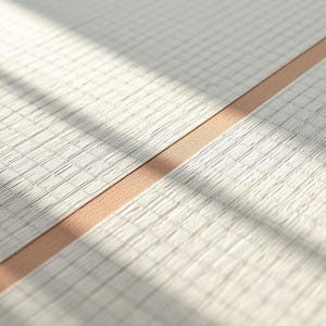 Può includere: Una superficie di carta bianca testurizzata con un motivo a griglia fine di linee sottili, divisa da una striscia diagonale liscia di materiale color marrone chiaro che attraversa l'inquadratura, creando contrasto tra la griglia e la superficie.