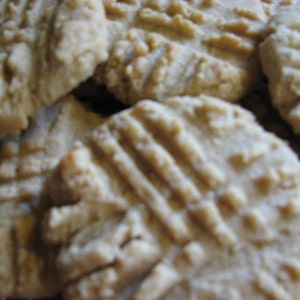 May include: A close-up of a pile of freshly baked, golden brown cookies. The cookies have a slightly crispy texture and a soft, chewy center.