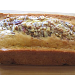 May include: A loaf of banana bread topped with chopped pecans.