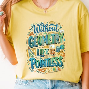 May include: A corn silk yellow t-shirt featuring a colorful graphic print with the text Without Geometry Life Is Pointless, surrounded by illustrations of mathematical tools including a protractor, compass, calculator, and geometric shapes.