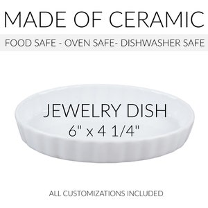 May include: White ceramic jewelry dish with a scalloped edge. It measures 6 inches by 4 1/4 inches. The dish is food safe, oven safe, and dishwasher safe.  "JEWELRY DISH" and "6" x 4 1/4" are printed on the dish.