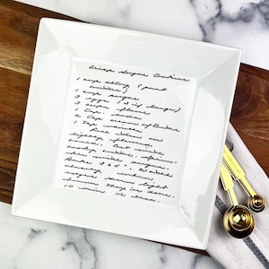 May include: White ceramic serving platter with a handwritten recipe for "Crisp Sugar Cookies" on it. The recipe includes ingredients like butter, sugar, flour, soda, and vanilla. The platter is a great way to display a family recipe or a favorite cookie recipe.
