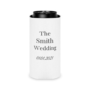 Peut inclure: Un refroidisseur de canette en mousse blanche avec un bord et une base noirs. L'avant présente un texte noir indiquant The Smith Wedding suivi de la date 01.01.2021 dans une police serif. La housse cylindrique s'adapte à une canette standard.
