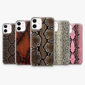 Könnte beinhalten: Fünf Smartphone-Hüllen in einer Reihe, jede mit einem ausgeprägten Schlangenhautmuster. Die Designs umfassen Farbvariationen in Braun, Rotbraun, Beige, Grau und Pink, alle mit einem Ausschnitt für die Doppelkamera oben links.