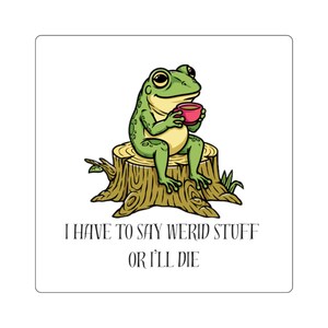 May include: A square sticker featuring a green frog with a light yellow belly sitting on a brown tree stump while holding a small pink cup. Below the illustration, the text reads: I HAVE TO SAY WERID STUFF OR I'LL DIE in black capital letters.