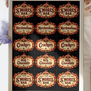 May include: A rectangular wooden frame containing a black sheet with fifteen repeating circus-themed labels. The labels feature red and gold marquee-style text reading S'mores Bar, Marshmallows, Crackers, Milk Chocolate, and Make Your Own S'mores Bar.
