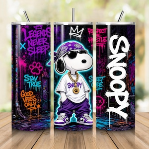 May include: A cylindrical tumbler with a straw featuring a cartoon dog wearing a purple bandana, sunglasses, a gold chain, a white t-shirt, and purple trousers. The background has graffiti art with text including Legends Never Sleep, Stay True, Good Vibes Only, and Snoopy.