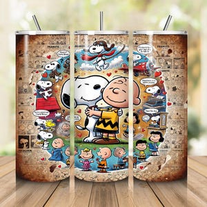 May include: A cylindrical stainless steel tumbler featuring a collage of Peanuts comic strips in a sepia tone. The design includes colorful illustrations of Snoopy and Charlie Brown, a red doghouse, and various speech bubbles with text.