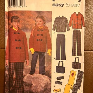 May include: A Simplicity easy-to-sew pattern envelope 5863 for sizes 7, 8, 10, 12, 14. The front displays illustrations of a hooded toggle coat, trousers, a tote bag, mittens, and a scarf, with photos of children wearing the coat and trousers.