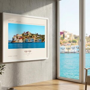 May include: A framed horizontal wall art print featuring a vibrant photograph of colorful Mediterranean coastal buildings along a blue harbor. The print includes the text Kastellorizo, Yunanistan at the top and the phrase siga siga at the bottom.