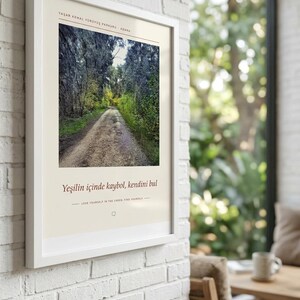 May include: A framed wall art print featuring a photograph of a dirt path winding through a dense forest. The print includes the text "YAŞAR KEMAL Y&Uuml;R&Uuml;Y&Uuml;Ş PARKURU - ADANA" at the top and "Yeşilin i&ccedil;inde kaybol, kendini bul" with the English translation below.