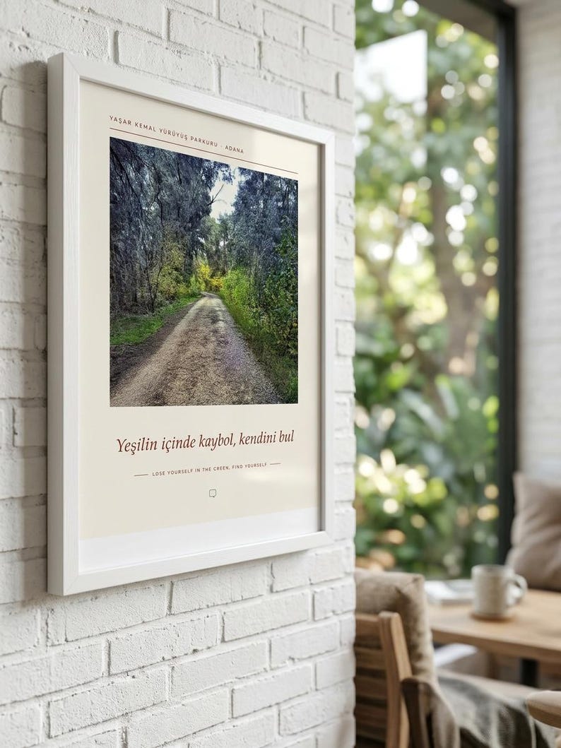 May include: A framed wall art print featuring a photograph of a dirt path winding through a dense forest. The print includes the text "YAŞAR KEMAL Y&Uuml;R&Uuml;Y&Uuml;Ş PARKURU - ADANA" at the top and "Yeşilin i&ccedil;inde kaybol, kendini bul" with the English translation below.