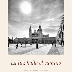 Op de afbeelding: Een zwart-witfoto van de Plaza de la Armer&iacute;a in Madrid, met de Almudena-kathedraal onder een felle zon. De tekst 'PLAZA DE LA ARMER&Iacute;A &middot; MADRID' staat bovenaan, met 'La luz halla el camino' en 'IŞIK YOLUNU BULUR' aan de onderzijde van de afbeelding.