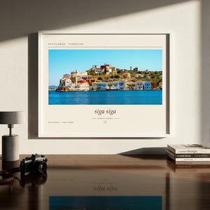 May include: A framed horizontal wall art print featuring a vibrant photograph of the Greek island of Kastellorizo with colorful buildings along the water. The print includes the text Kastellorizo, Yunanistan, siga siga, and photography by Ahmet Alkan.