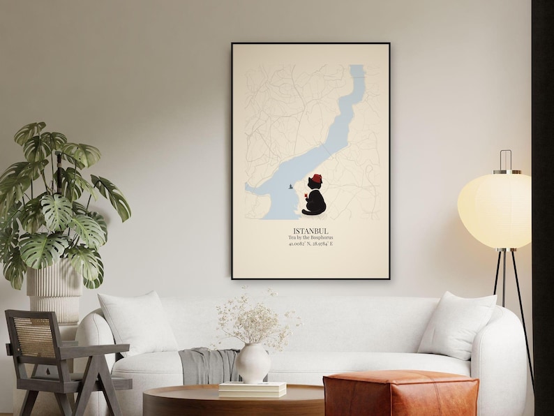 May include: A framed wall art print featuring a map of Istanbul with the Bosphorus in light blue. A black cat wearing a red fez sits by the water, holding a small glass of tea. Text reads: ISTANBUL, Tea by the Bosphorus, 41.0082&deg; N, 28.9784&deg; E.