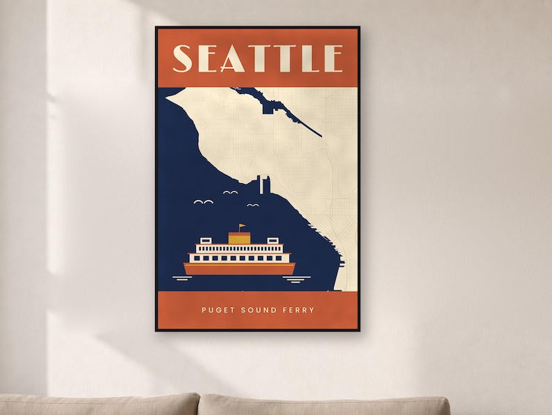 May include: A framed vertical wall art print featuring a stylized map of Seattle with a dark blue water section and a cream land section. An orange ferry boat is centered at the bottom with the text SEATTLE at the top and PUGET SOUND FERRY below.