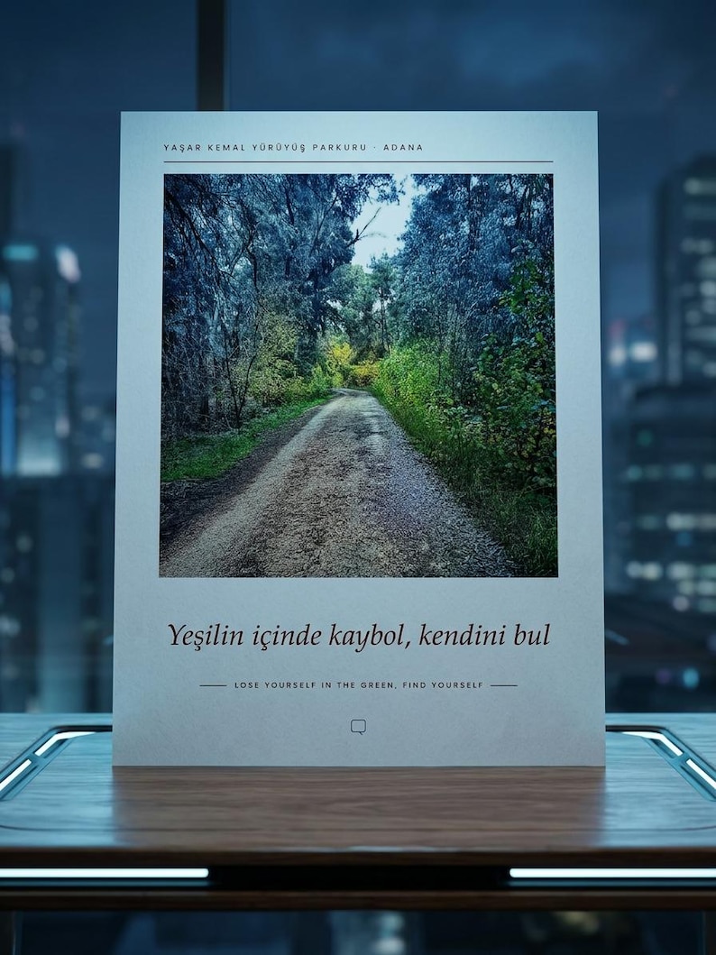 Puede incluir: Un p&oacute;ster rectangular con una fotograf&iacute;a de un camino de tierra que serpentea a trav&eacute;s de un bosque denso. El texto en la parte superior dice YAŞAR KEMAL Y&Uuml;R&Uuml;Y&Uuml;Ş PARKURU - ADANA. Debajo de la imagen, el texto dice Yeşilin i&ccedil;inde kaybol, kendini bul y LOSE YOURSELF IN THE GREEN, FIND YOURSELF.