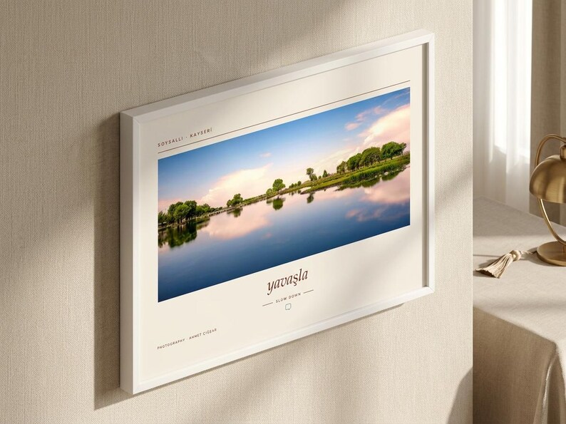 Pode incluir: Uma impress&atilde;o art&iacute;stica retangular com moldura branca apresentando uma fotografia de paisagem de um lago com &aacute;rvores sob um c&eacute;u azul. A impress&atilde;o inclui o texto SOYSALLI - KAYSERI, yavaşla, SLOW DOWN e PHOTOGRAPHY AHMET CIZAR.