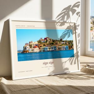 May include: A framed horizontal print featuring a vibrant photograph of the Greek island Kastellorizo with colorful buildings along the blue water. The print includes the text KASTELLORIZO - YUNANISTAN, siga siga, SLOWLY, SLOWLY, and PHOTOGRAPHY AHMET CİĞER.