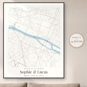 May include: A framed map print of Paris featuring black street lines and a light blue river. The text reads WHERE IT ALL BEGAN, Sophie & Lucas, PARIS, MAY 18, 2019. A circular badge on the right side displays the text READY IN 24 HOURS.