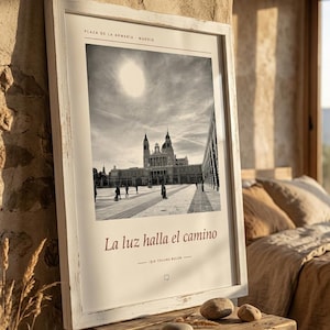 Op de afbeelding: Een ingelijste zwart-witfoto van de Plaza de la Armer&iacute;a in Madrid, met het Koninklijk Paleis onder een felle zon. De print bevat de tekst 'PLAZA DE LA ARMER&Iacute;A MADRID', 'La luz halla el camino' en 'IŞIK YOLUNU BULUR'.