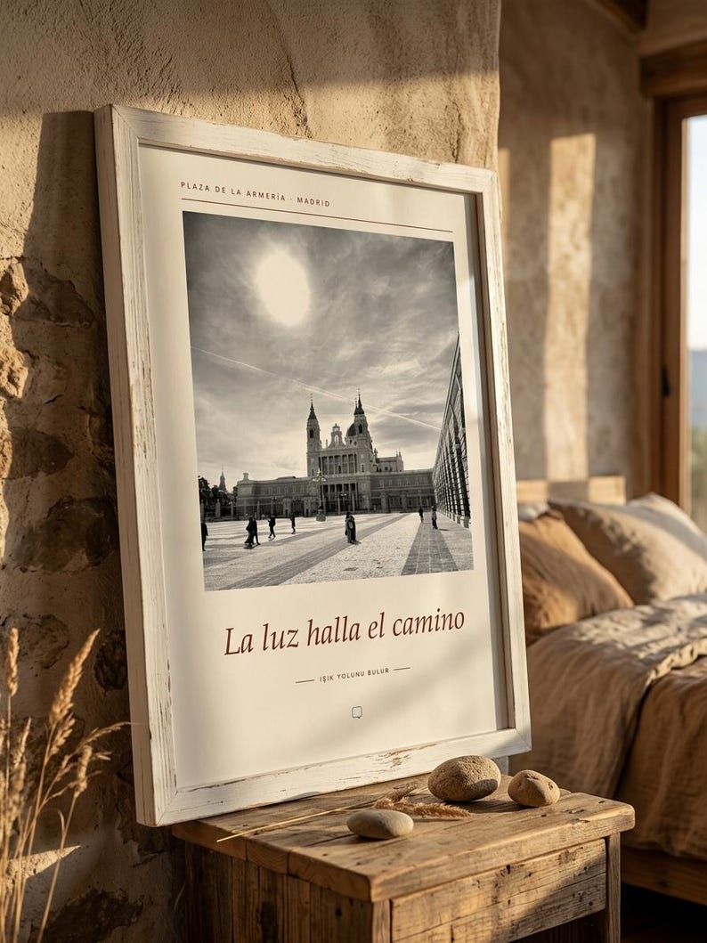 Op de afbeelding: Een ingelijste zwart-witfoto van de Plaza de la Armer&iacute;a in Madrid, met het Koninklijk Paleis onder een felle zon. De print bevat de tekst 'PLAZA DE LA ARMER&Iacute;A MADRID', 'La luz halla el camino' en 'IŞIK YOLUNU BULUR'.