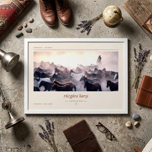 May include: A rectangular white-framed wall art print featuring a photograph of a herd of horses running through dust. The print includes the text "r&uuml;zg&acirc;ra karşı" centred below the image, with additional small text at the top and bottom corners.
