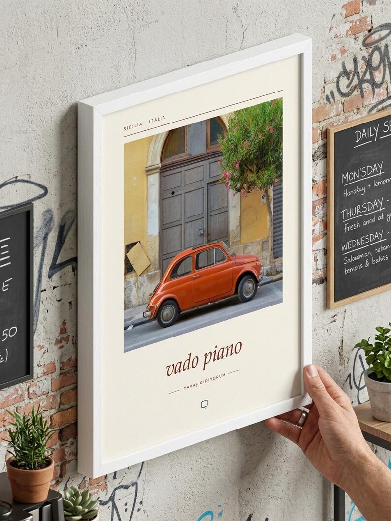May include: A framed wall art print featuring a vintage orange car parked in front of a building in Sicily, Italy. The print includes the text "SICILIA - ITALIA" at the top and "vado piano" with "YAVAS GIDIYORUM" below the car image.