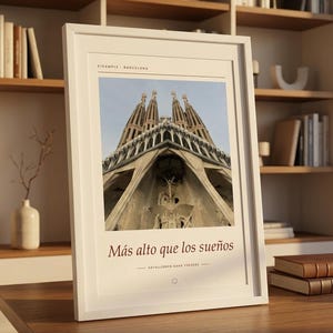 K&ouml;nnte beinhalten: Ein wei&szlig; gerahmter Kunstdruck mit einer Froschperspektive der Sagrada Familia in Barcelona. Oben steht der Text EIXAMPLE BARCELONA, w&auml;hrend darunter die S&auml;tze M&aacute;s alto que los sue&ntilde;os und HAYALLERDEN DAHA Y&Uuml;KSEĞE zu sehen sind.
