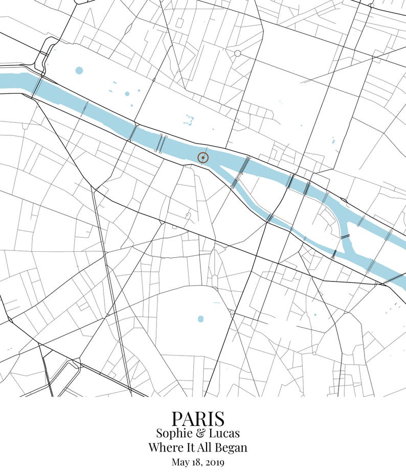 May include: A map print of Paris featuring black street lines on a white background with a light blue river. A circular marker highlights a specific location. Text at the bottom reads: PARIS, Sophie & Lucas, Where It All Began, May 18, 2019.