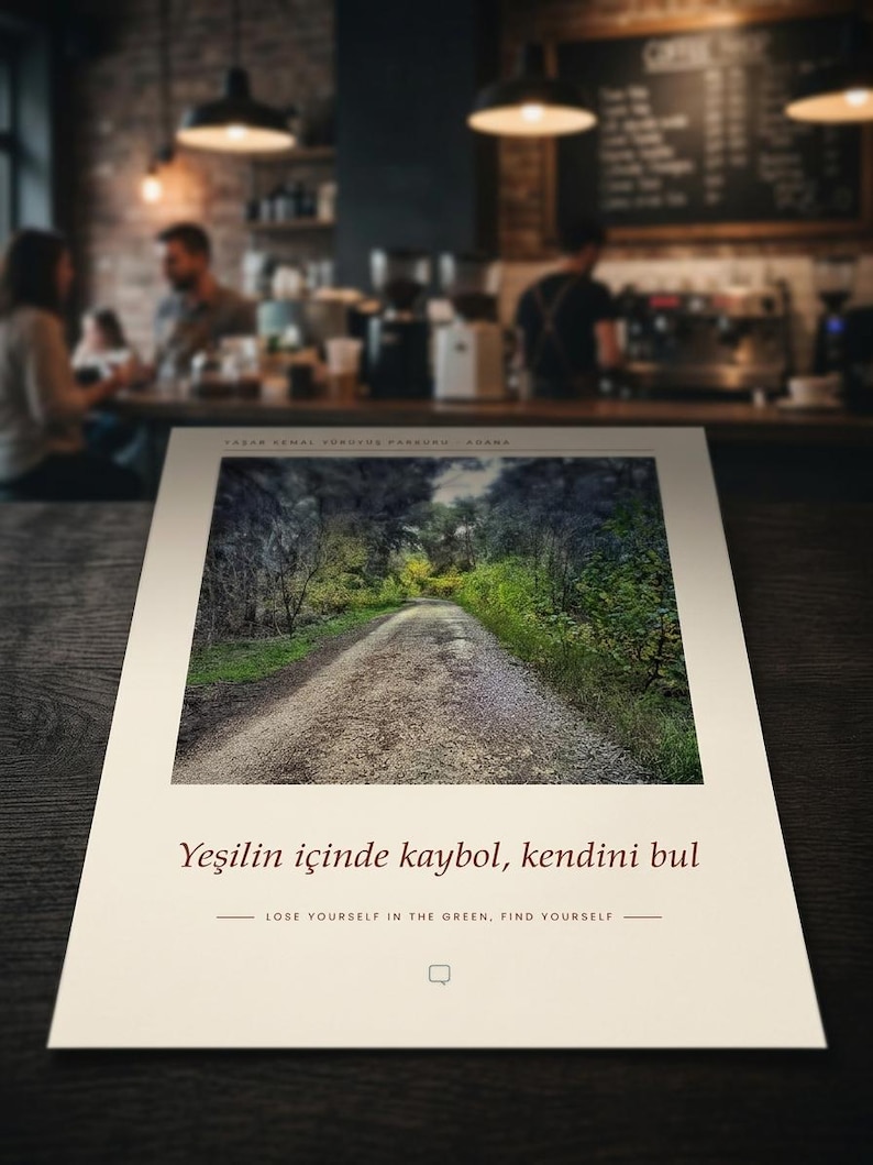 Puede incluir: Una impresi&oacute;n rectangular que presenta una fotograf&iacute;a de un camino de grava que serpentea a trav&eacute;s de un bosque denso. Debajo de la imagen, el texto dice: "Yeşilin i&ccedil;inde kaybol, kendini bul" y "LOSE YOURSELF IN THE GREEN, FIND YOURSELF" con un icono de burbuja.
