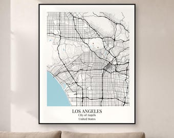 May include: A framed wall art print featuring a black and white street map of Los Angeles, California. The map displays a grid of roads, a light blue coastline, and the text LOS ANGELES, City of Angels, United States at the bottom.
