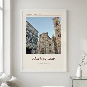 Puede incluir: Una l&aacute;mina de arte mural enmarcada con una fotograf&iacute;a de la Piazza del Duomo en Florencia, Italia. La impresi&oacute;n incluye el texto Piazza del Duomo Firenze en la parte superior y Alza lo sguardo y BASINI KALDIR en la parte inferior con borde crema.