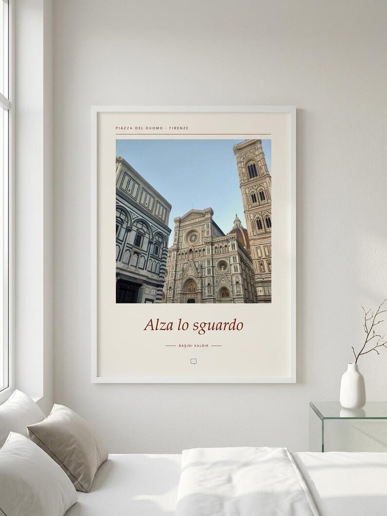 Puede incluir: Una l&aacute;mina de arte mural enmarcada con una fotograf&iacute;a de la Piazza del Duomo en Florencia, Italia. La impresi&oacute;n incluye el texto Piazza del Duomo Firenze en la parte superior y Alza lo sguardo y BASINI KALDIR en la parte inferior con borde crema.