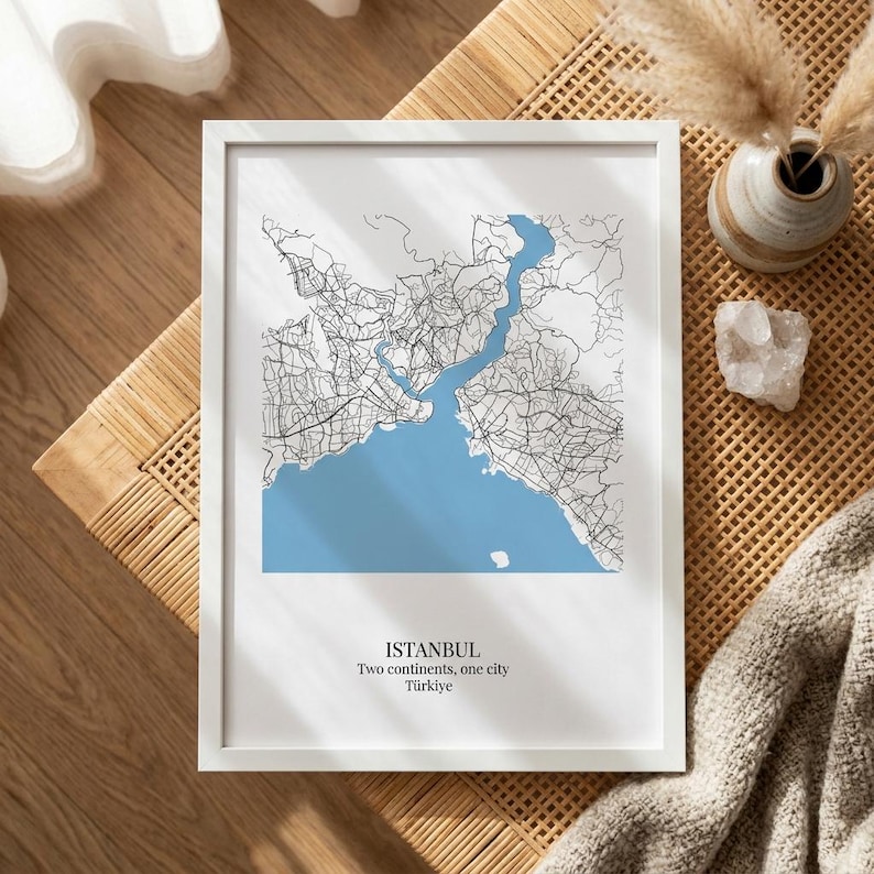 Puede incluir: Una l&aacute;mina enmarcada con un mapa estilizado de Estambul, Turqu&iacute;a. El mapa muestra redes de carreteras negras sobre un fondo blanco con el estrecho del B&oacute;sforo en azul claro. El texto en la parte inferior dice: ISTANBUL, Two continents, one city, T&uuml;rkiye.