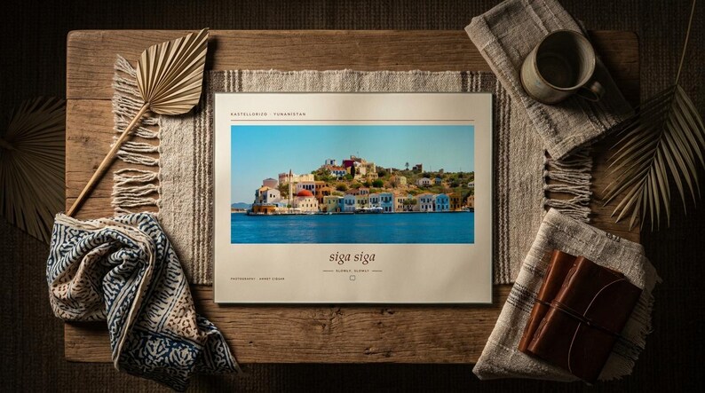 May include: A rectangular book with a cream-colored cover featuring a photograph of a coastal town with colorful buildings by the blue sea. The text reads Castellorizo, Yunanistan, siga siga, and photography: Ahmet Fidan in black serif font.