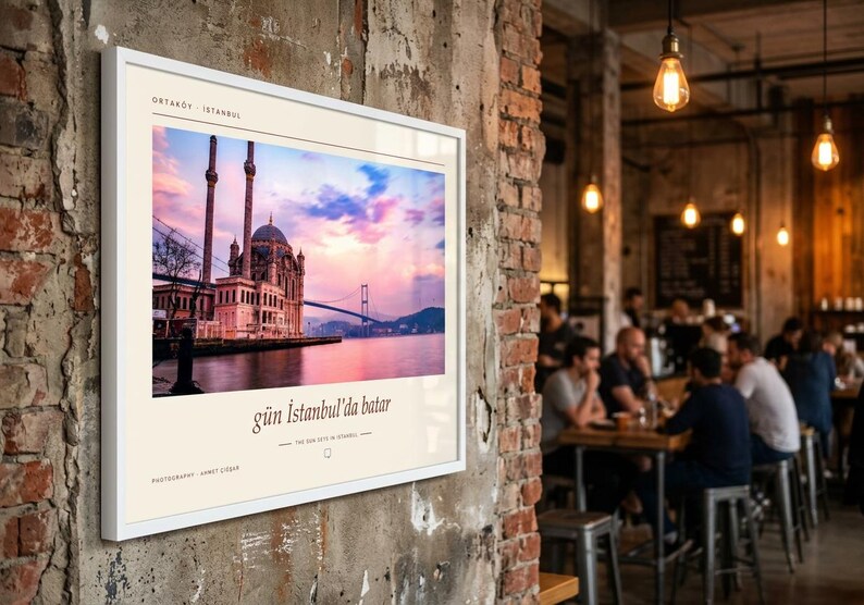 May include: A framed wall print featuring a photograph of the Ortak&ouml;y Mosque in Istanbul at sunset, with the text "ORTAK&Ouml;Y - ISTANBUL", "g&uuml;n İstanbul'da batar", and "THE SUN SETS IN ISTANBUL" printed in black on a cream-coloured border.
