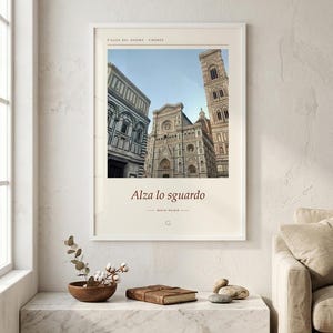 Op de afbeelding: Een ingelijste kunstprint met een foto van de Piazza del Duomo in Florence, Itali&euml;. De print bevat de tekst Piazza del Duomo Firenze bovenaan en de zin Alza lo sguardo met de naam Basini Kaldir onder de afbeelding.